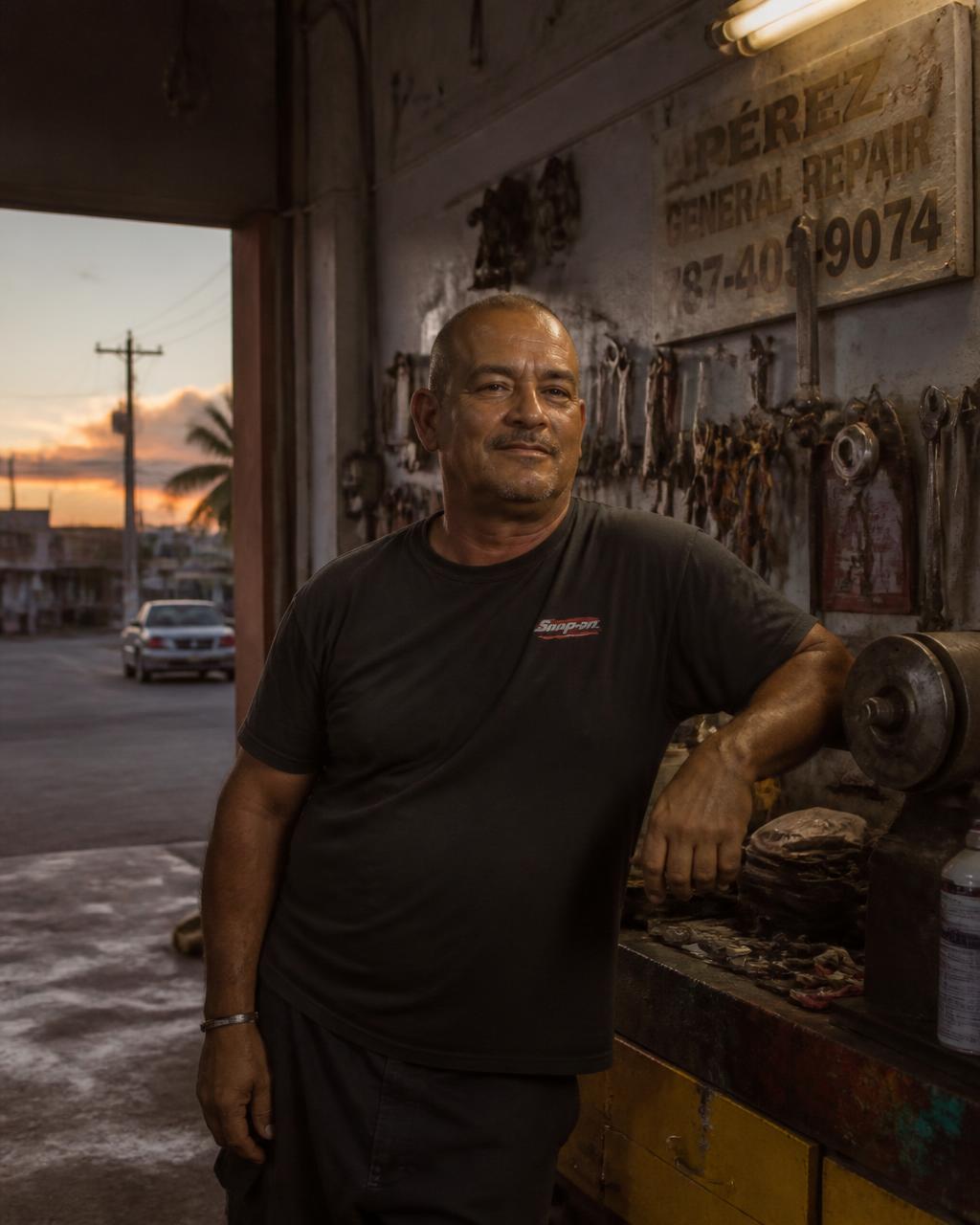 Trabajador de regreso en Puerto Rico en su propio taller de reparación con luz cálida del atardecer